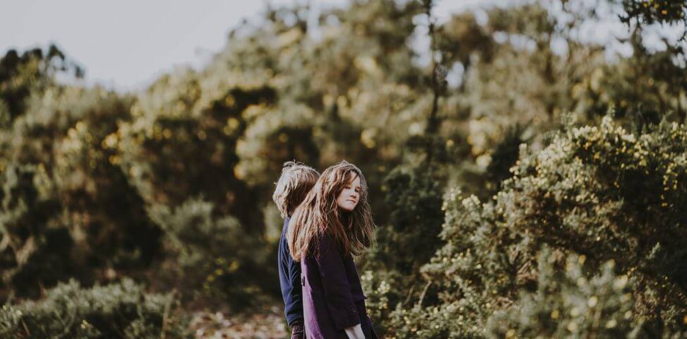 Two adolescents on a walk in the woods.