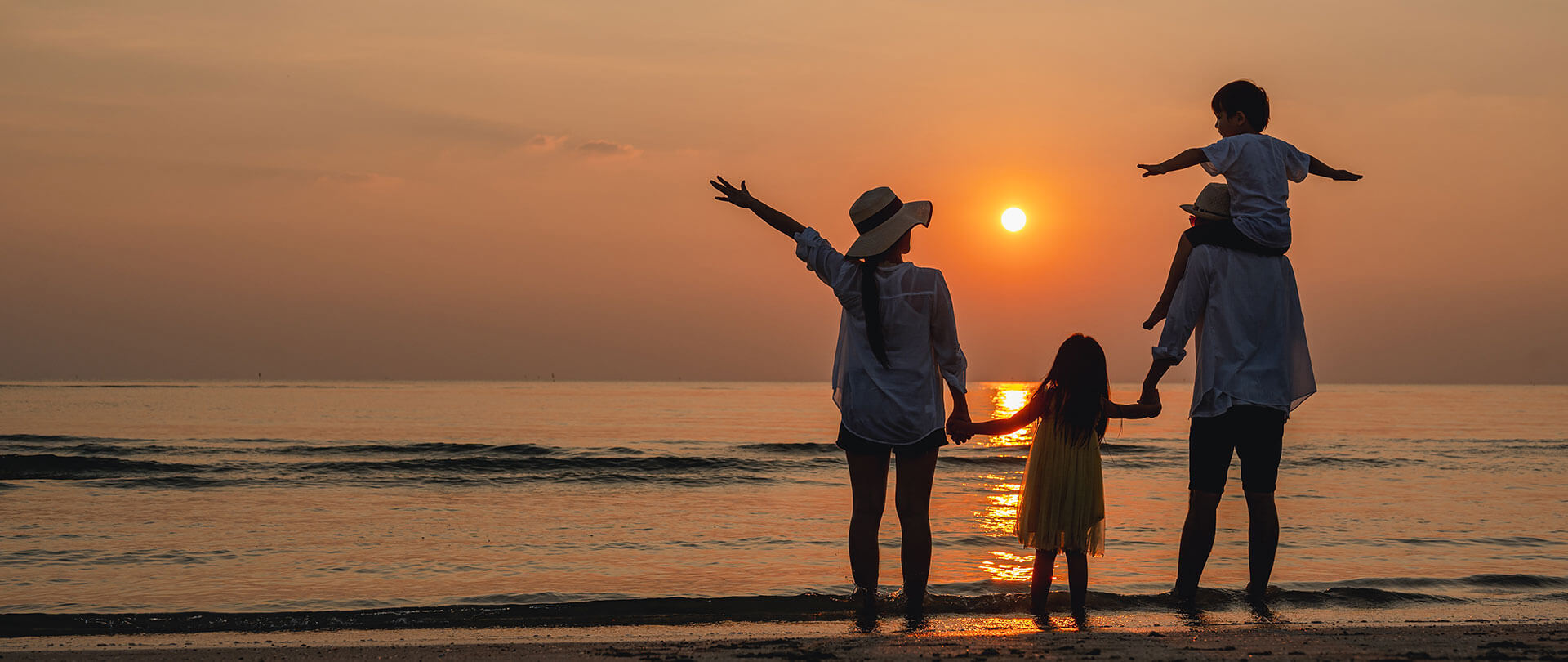 Family on beach at sunset