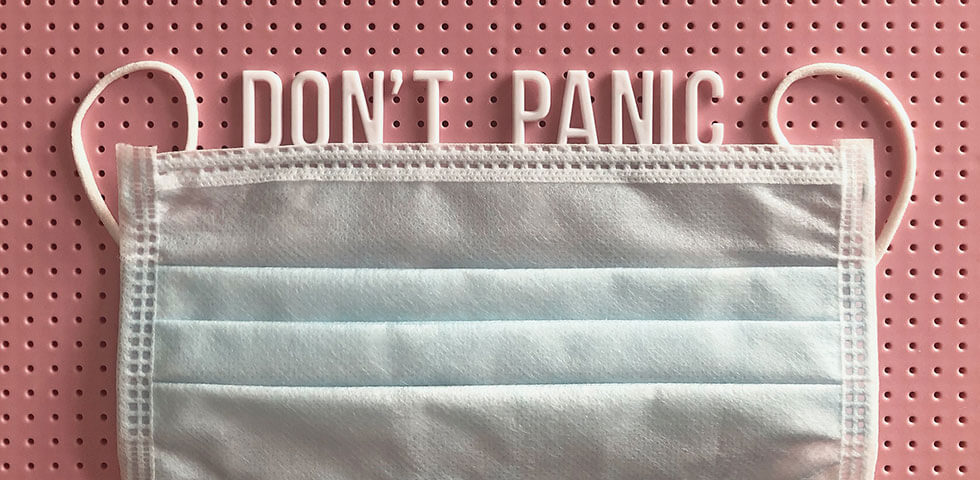 Medical mask on letter board with DON'T PANIC spelled out.