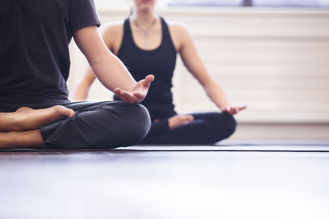 Man and woman doing gentle yoga for therapeutic benefits